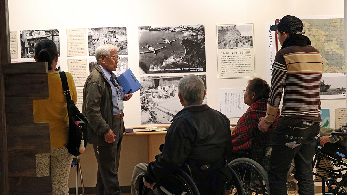 沖縄戦の展示を案内する回復者の平良仁雄さん
