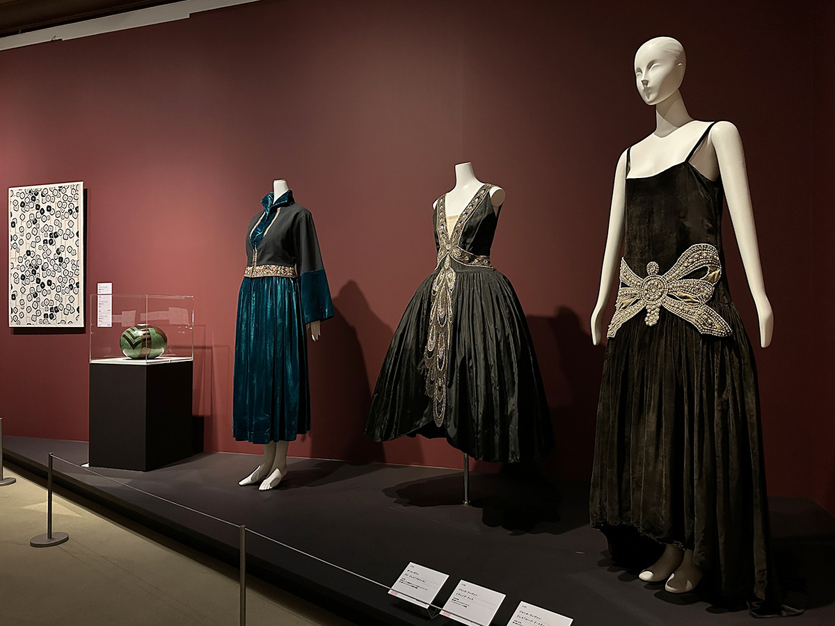 東京都庭園美術館「交歓するモダン　機能と装飾のポリフォニー」会場より　chapter 3「1919-1925」　（左奥から）フランシス・ジュールダン《壁紙サンプル》1924年頃 パリ装飾美術館 ／ ジャン・デュナン《球体花瓶（緑、黒）》1925年頃 東京国立近代美術館 ／ ポール・ポワレ《デイ・ドレス「ブルトンヌ」》1921年 島根県立石見美術館［展示期間：2022年12月17日～2023年1月22日］ ／ ジャンヌ・ランヴァン《ドレス「ローブ・ド・スティル」》1926-27年 神戸ファッション美術館 ／ ジャンヌ・ランヴァン《イヴニング・ドレス》1924年頃 京都服飾文化研究財団
