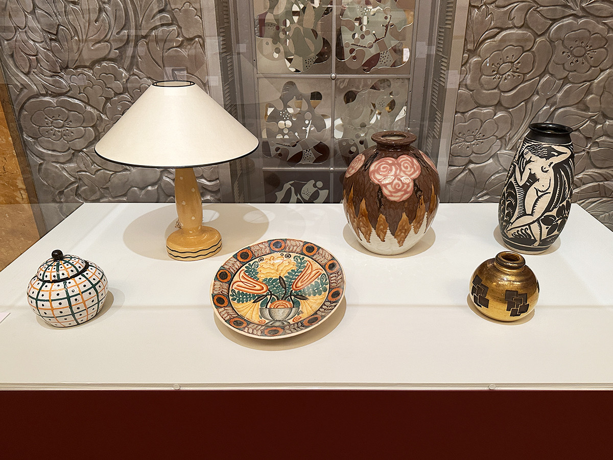 東京都庭園美術館「交歓するモダン　機能と装飾のポリフォニー」会場より　chapter 3「1919-1925」　（前列左から）フランシス・ジュールダン《蓋つきのポット》1920-21年 ポール・エリュアール歴史美術館・サンドニ ／ ルネ・ピュトー《花模様大皿》1920-25年頃 東京国立近代美術館 ／ ジャン・リュス《花瓶》制作年不詳 東京都庭園美術館 ／ （後列左から）フランシス・ジュールダン《ランプ》1920-21年 ポール・エリュアール歴史美術館・サンドニ ／ デザイン：アンリ・ラパン、絵付：カミーユ・タロー《花瓶》1925年頃 東京都庭園美術館 ／ ルネ・ピュトー《裸婦図壺》1920-25年頃 東京国立近代美術館
