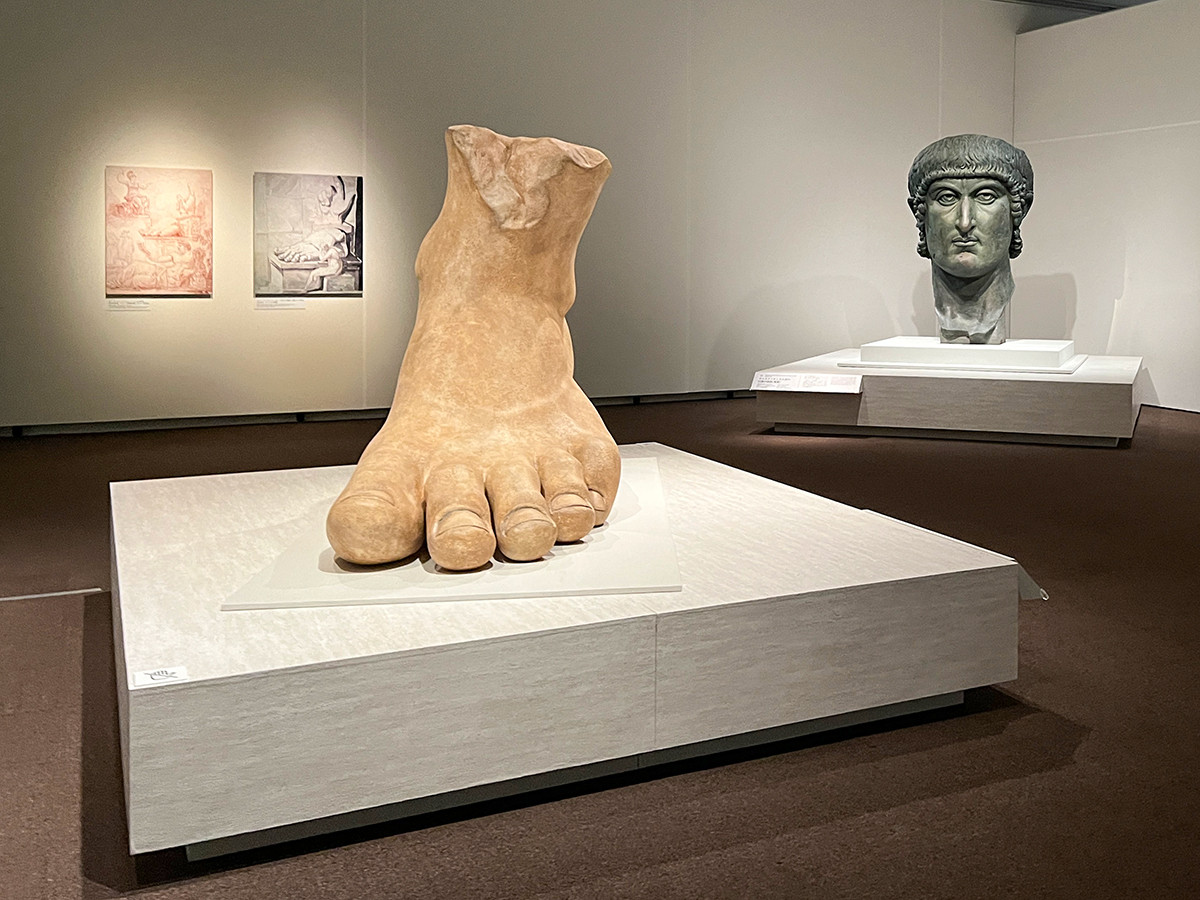 （左から）《コンスタンティヌス帝の 巨像の左足（複製）》2021年（原作は312年頃） ローマ文明博物館蔵 ／ 《コンスタンティヌス帝の 巨像の頭部（複製）》1930年代（原作は330-37年） ローマ文明博物館蔵