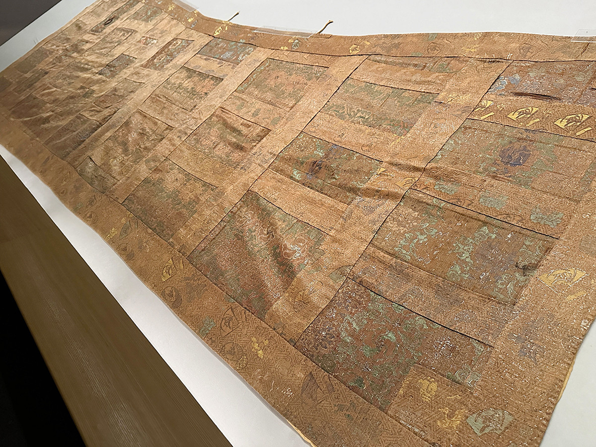 根津美術館「繡と織 ― 華麗なる日本染織の世界 ―」会場より 《九条袈裟 紅地花唐草模様黄緞》桃山時代 17世紀