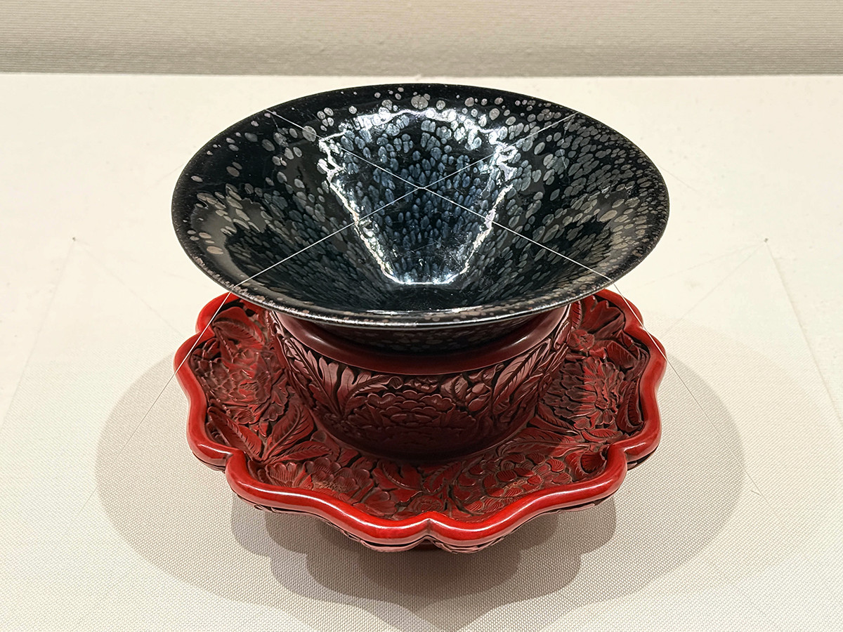 静嘉堂@丸の内「黒の奇跡・曜変天目の秘密」会場より　重要文化財《油滴天目》　付属　花卉文堆朱天目台「新」銘　建窯　南宋時代（12～13世紀）明時代（15世紀）