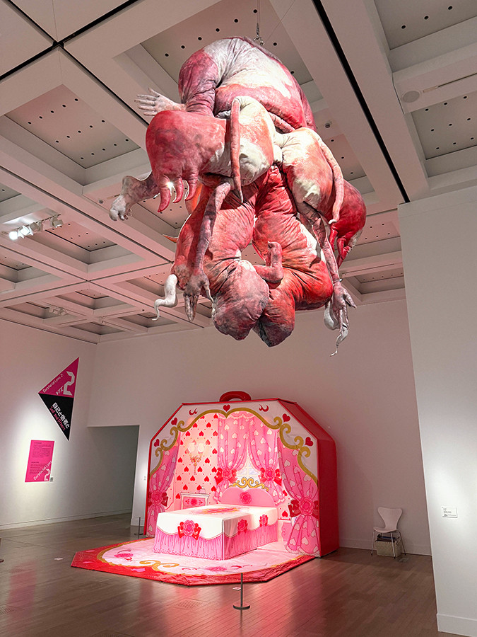 国立新美術館「時代のプリズム：日本で生まれた美術表現 1989-2010」会場より　（上）イ・ブル《無題（渇望　赤）》1998/2011　リウム美術館蔵 ／ （下）西山美なコ《ザ・ピんくはうす》1991/2006　金沢21世紀美術館蔵