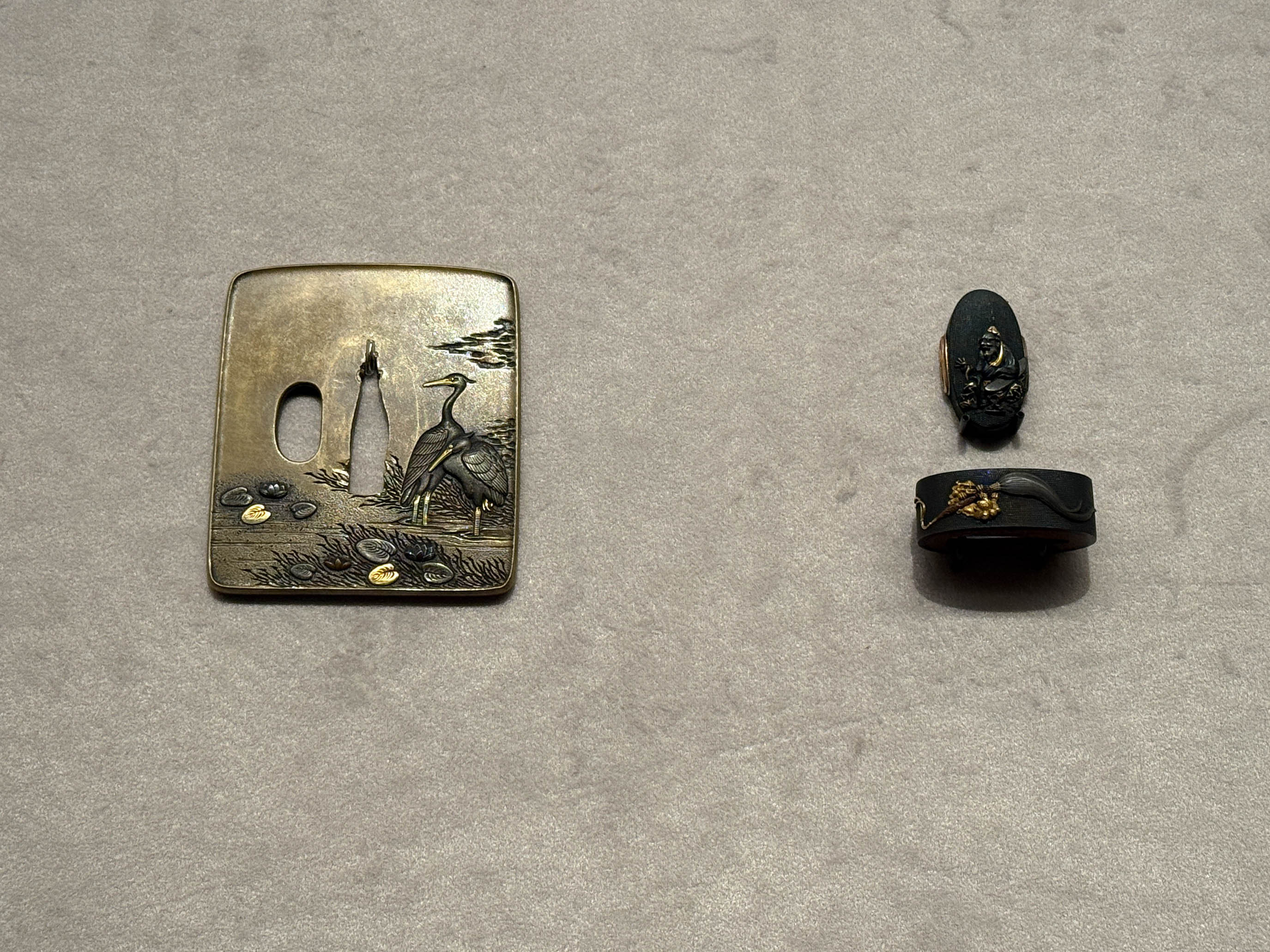 （左から）《蓮鷺図鐔》大月光興 作　江戸時代　18～19世紀　根津美術館蔵 ／ 《維摩居士図縁頭》大月光興 作　江戸時代　18～19世紀　根津美術館蔵