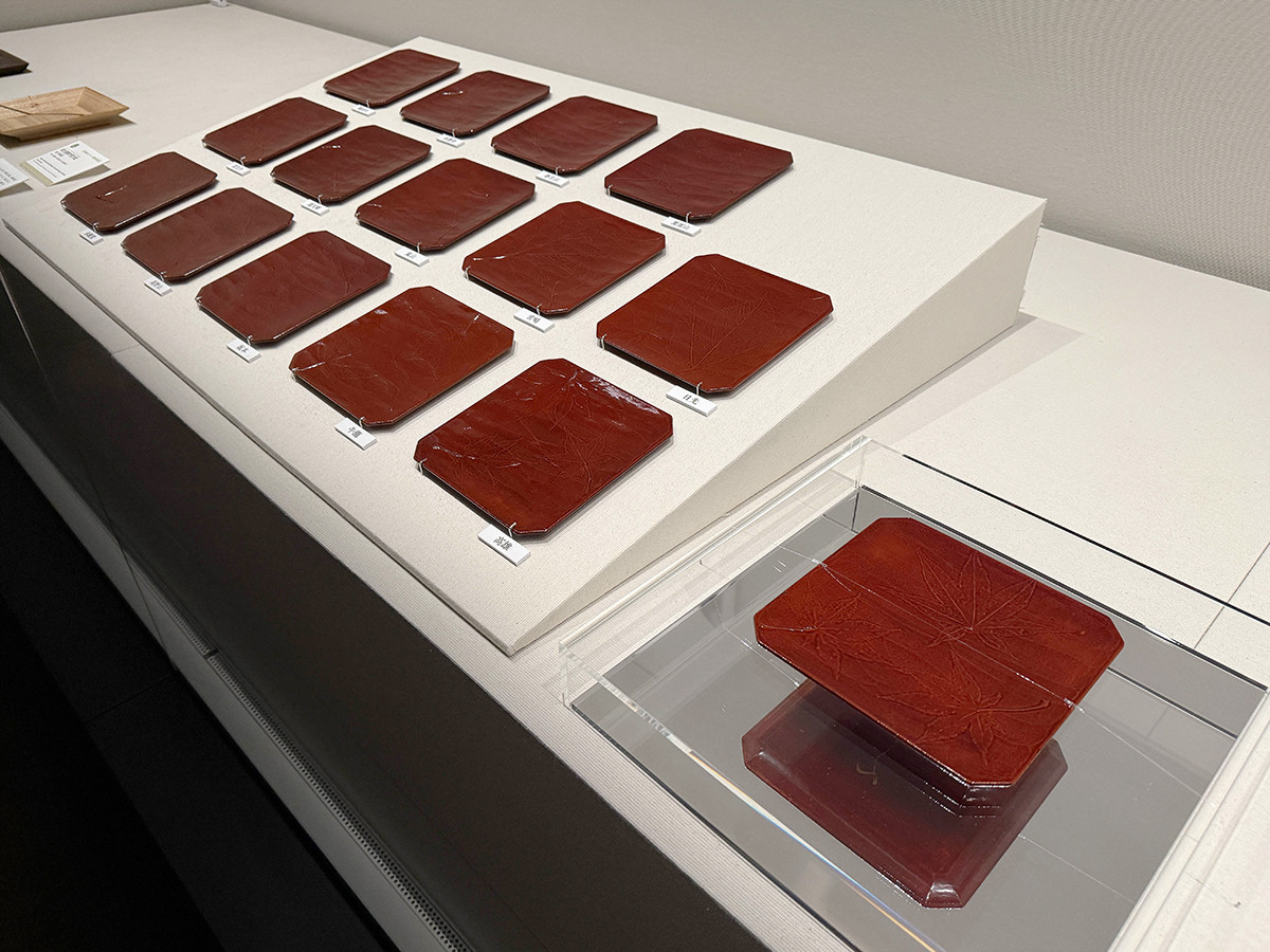 静嘉堂文庫美術館「美を味わう ― 懐石のうつわと茶の湯」会場より　《溜塗紅葉張交銘々盆》飛来一閑　明治時代（19世紀後半～20世紀前半）