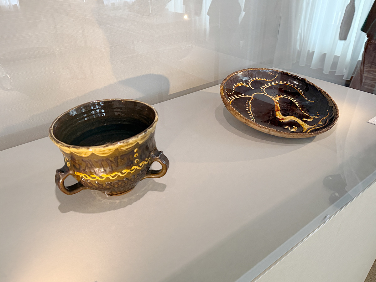東京都庭園美術館「ルーシー・リー展―東西をつなぐ優美のうつわ―」会場より 2章「ロンドンでの出会い」 (左から)バーナード・リーチ《スリップ釉耳付鉢》1922年 京都国立近代美術館 / バーナード・リーチ《スリップ釉柳水禽文皿》 1924年 京都国立近代美術館