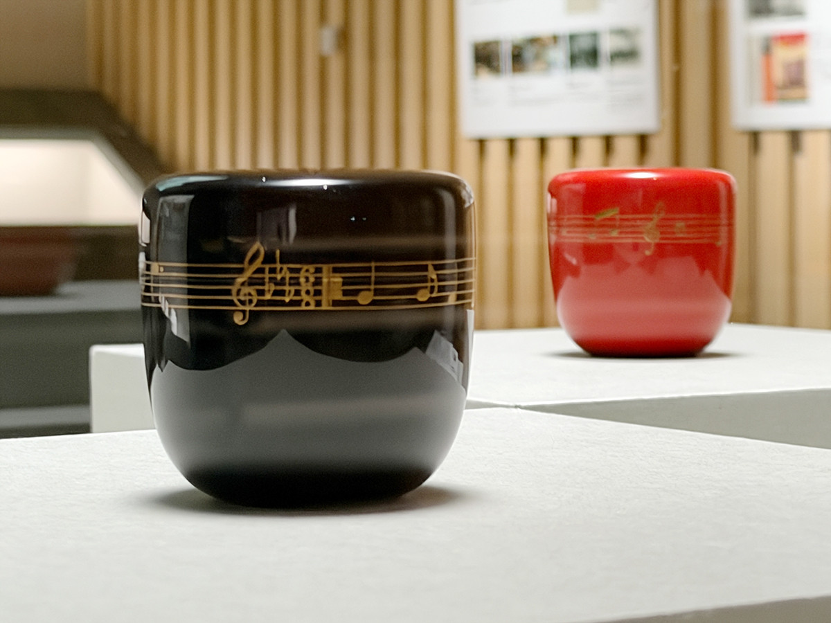 サントリー美術館「逸翁美術館コレクション　蕪村・呉春と茶の湯の名品」会場より　（左手前）《黒地歌劇雛祭楽譜蒔絵棗　逸翁好》三砂良哉　昭和8年（1933）［通期展示］